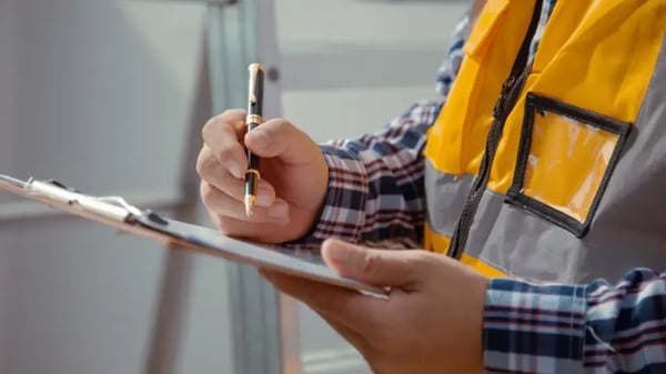 Building inspector with clipboard on-site